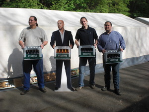 Von links nach rechts: Hendrik, Bruce Willis (Pappaufsteller), Mathias und Dennis die jeweils einen Kasten Veltins tragen