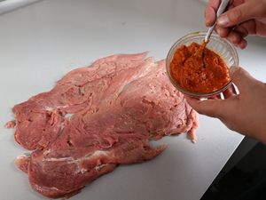 Schweinefilet wird mit Pesto bestrichen