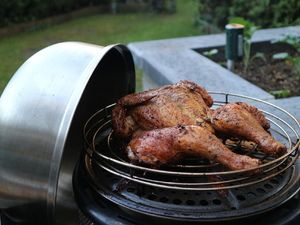 Gegrilltes Platthuhn im geöffneten Tischgrill