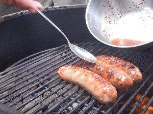Bratwürste werden auf dem Grill mariniert