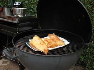 Fertiger Backfisch auf einer Platte im Kugelgrill