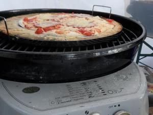 Pizza auf dem Pizzastein im Grill