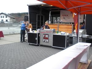 Bühne und Grillstationen unter roten Pavillons