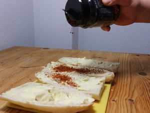 Chipotle-Gewürz wird auf die gebutterten Baguettes gestreut