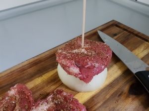 Gewürzte Fleischscheiben werden auf den Spieß gesteckt