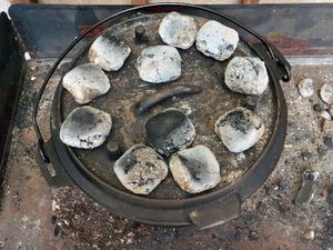 Dutch Oven mit Briketts auf dem Deckel