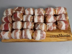 Viele in Speck gewickelte Kartoffeln auf dem Brett