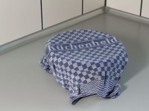 Eine mit einem feuchten Küchentuch abgedeckte Schüssel. Das Küchentuch hat die Aufschrift Küchenheld.
