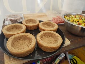Ausgehöhlte Brotlaibe als Schüsseln, daneben eine Schale Gemüse