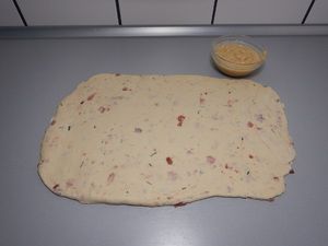 Ausgerollter Teig mit Speckwürfeln