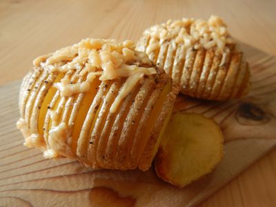 Zwei Hasselback-Kartoffeln mit Käse überbacken