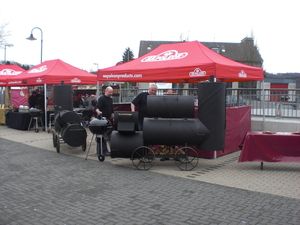 Großer Smoker auf Rädern vor roten Pavillons