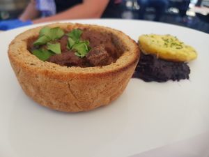 Gulasch im Brot mit Rotkohl und Kartoffel