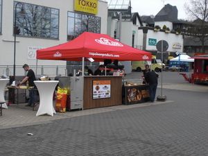 Grillstand unter rotem Pavillon auf dem Platz