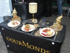 Drei Showteller auf schwarzen Tisch. Dekoriert mit goldenen Gartenzwergen und kleiner Nachtischlampe